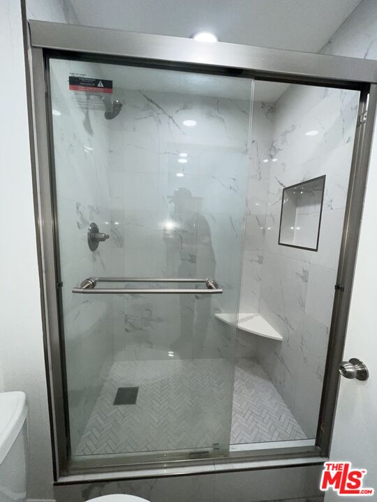600 West 9th Street, Unit 316 Los Angeles, CA 90015 - Photo 21 of 29 a bathroom with a glass shower door