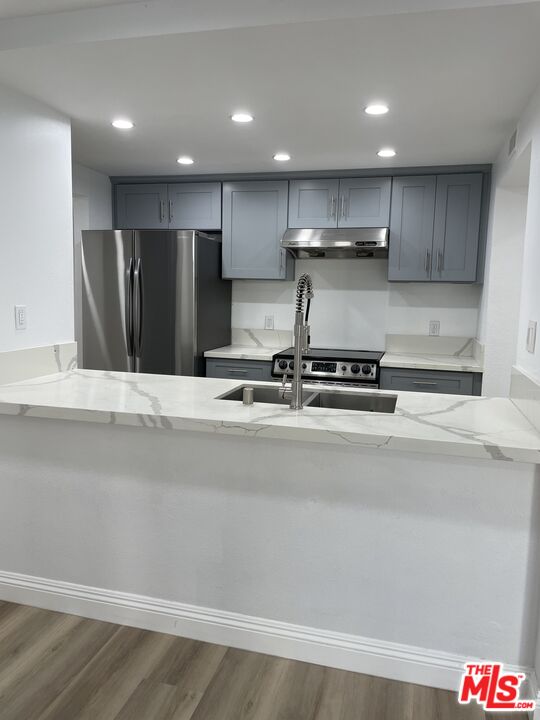 600 West 9th Street, Unit 316 Los Angeles, CA 90015 - Photo 5 of 29 a view of kitchen with stainless steel appliances kitchen island sink refrigerator and cabinets
