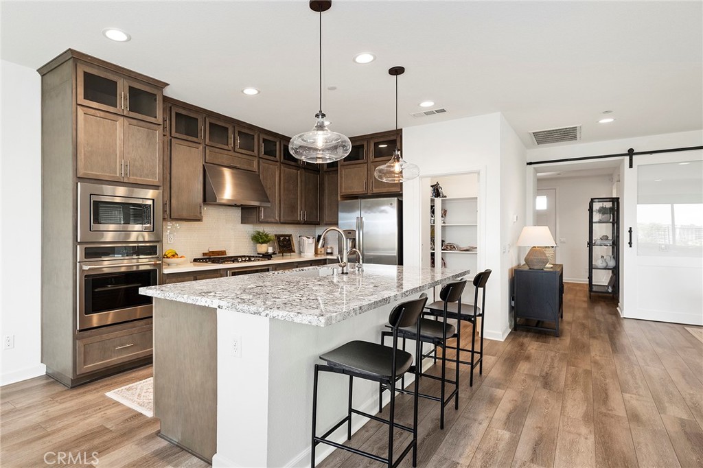 32151 Everview Terrace Temecula, CA 92591 - Photo 4 of 39 a kitchen with stainless steel appliances granite countertop a stove refrigerator sink and microwave