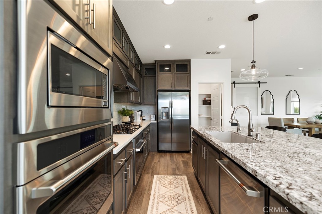 32151 Everview Terrace Temecula, CA 92591 - Photo 6 of 39 a kitchen with stainless steel appliances granite countertop a kitchen island a stove and a sink