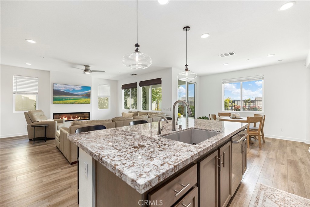32151 Everview Terrace Temecula, CA 92591 - Photo 7 of 39 a kitchen with granite countertop kitchen island stainless steel appliances sink stove and wooden floor
