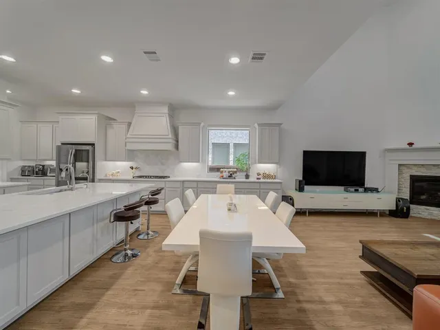 a kitchen with white cabinets and sink