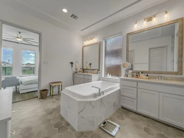 a bathroom with a double vanity sink a toilet a mirror and shower