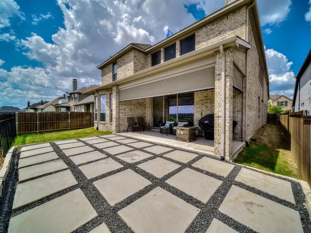 a view of a patio with a table chairs and a floor to ceiling window