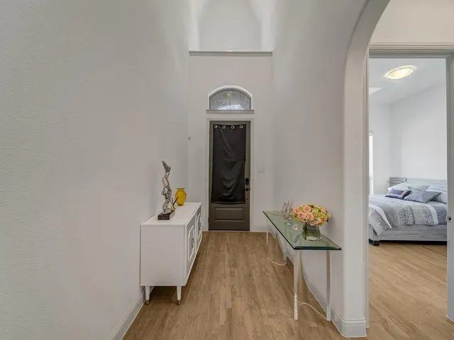 a hallway with a wooden floor and furniture