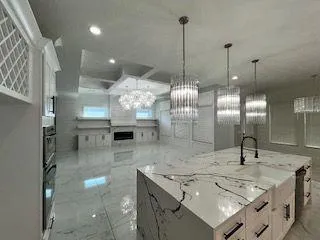 a view of a kitchen with a sink and chandelier