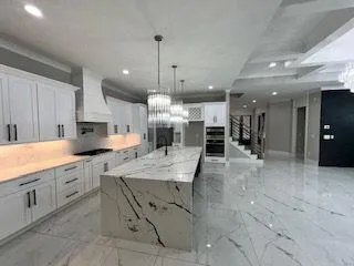 a large kitchen with a large counter top appliances and cabinets