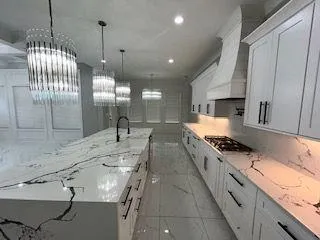 a large kitchen with granite countertop a sink a counter top space appliances and cabinets