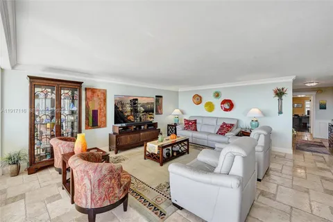 a living room with furniture a flat screen tv and a window