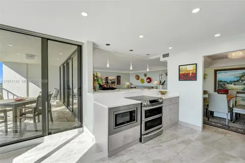 a kitchen with granite countertop a sink stove and refrigerator