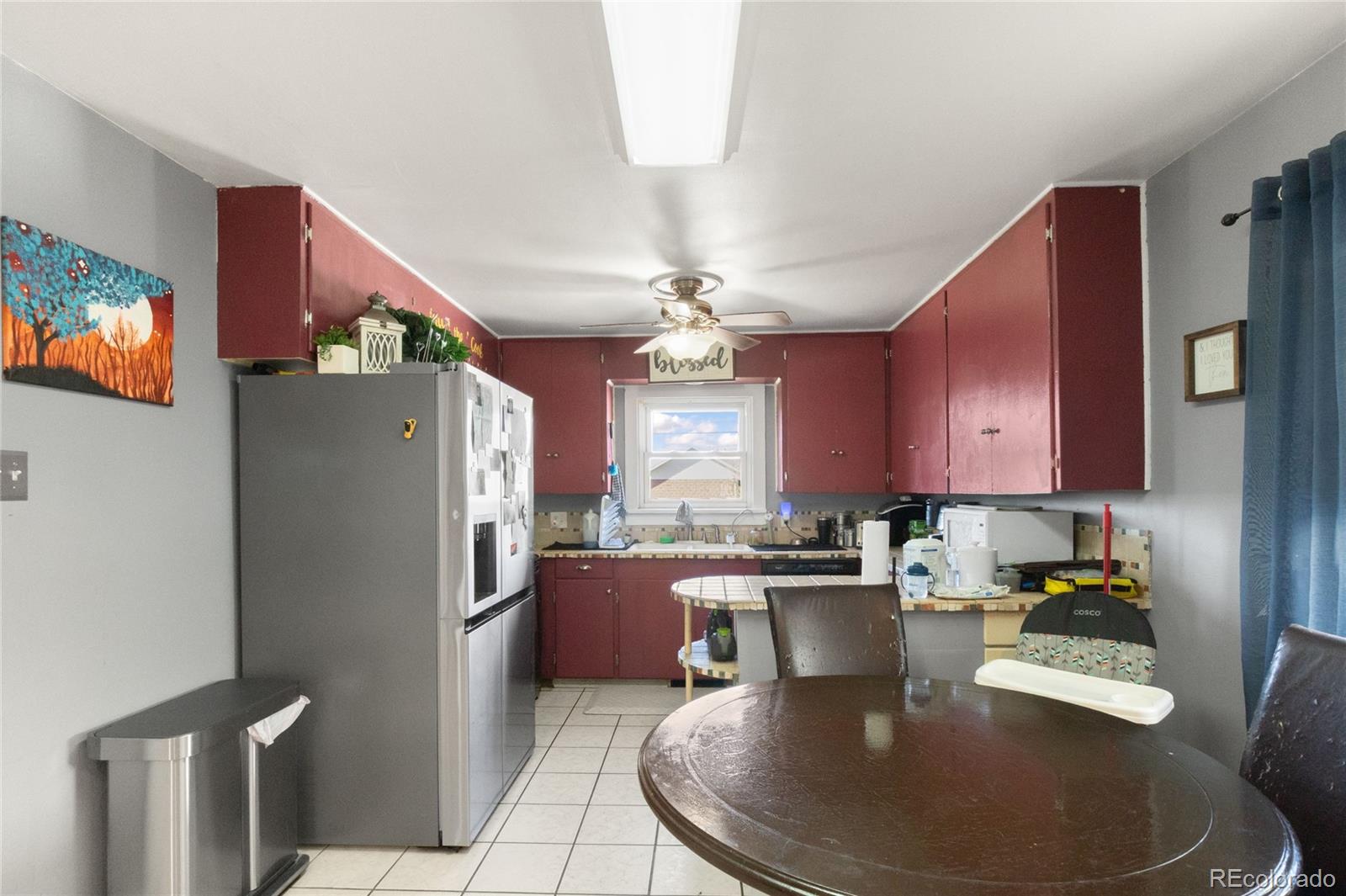 229 4th Street Fort Lupton, CO 80621 - Photo 5 of 25 a kitchen with stainless steel appliances granite countertop a refrigerator a sink a stove a dining table and chairs