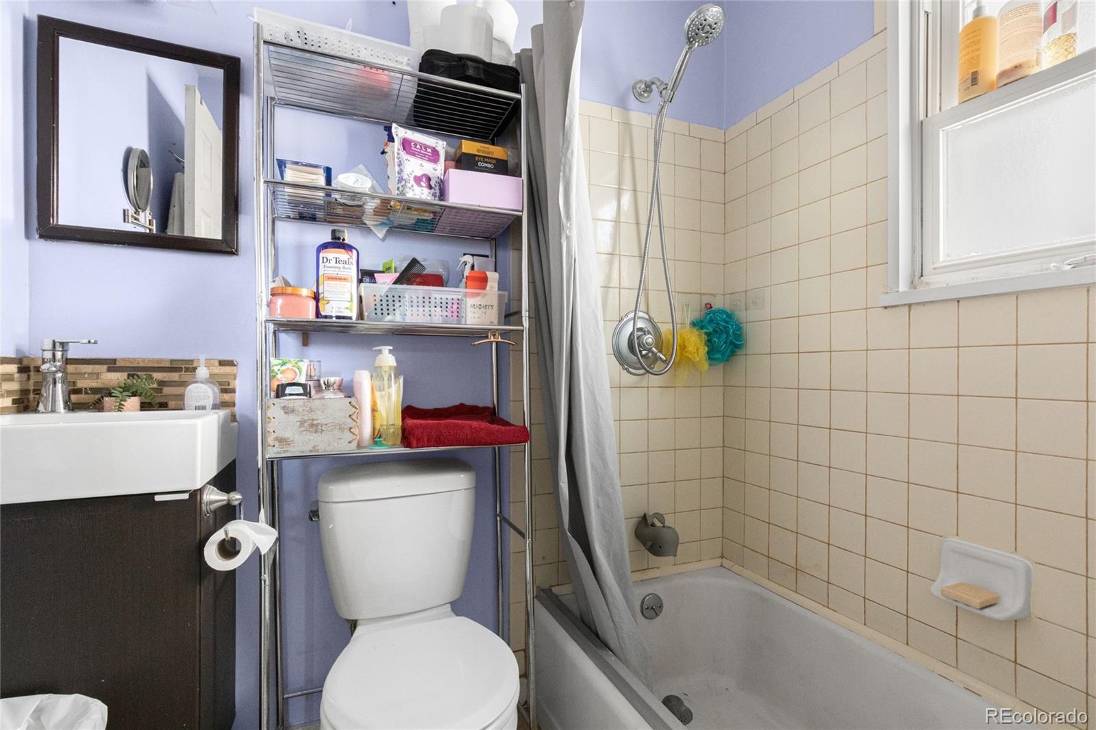 229 4th Street Fort Lupton, CO 80621 - Photo 10 of 25 a bathroom with a toilet and a shower curtain