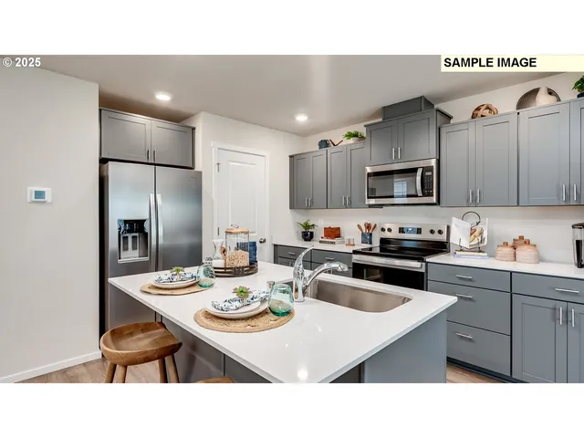 a kitchen with kitchen island a white counter top space a sink appliances and cabinets