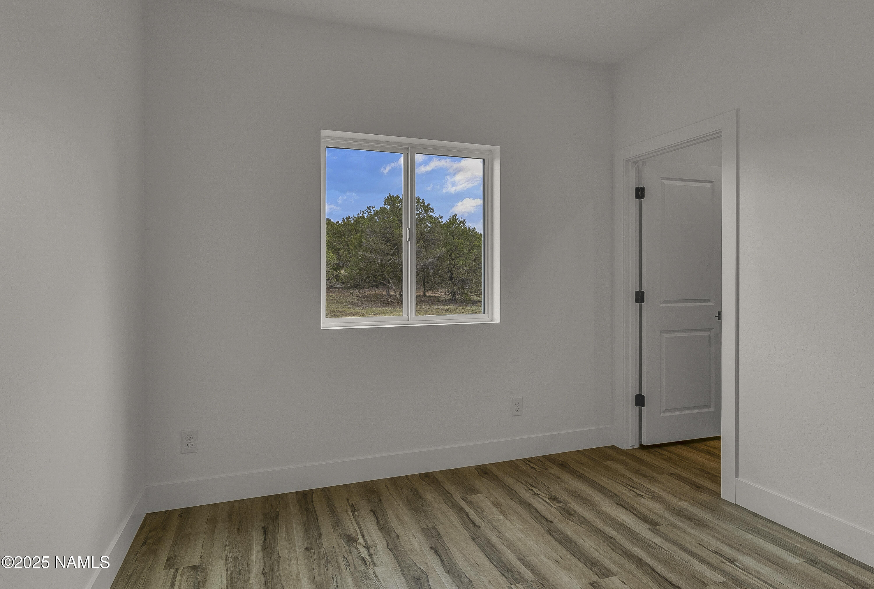 7935 North Red Lake Road Williams, AZ 86046 - Photo 27 of 31 an empty room with wooden floor and a window