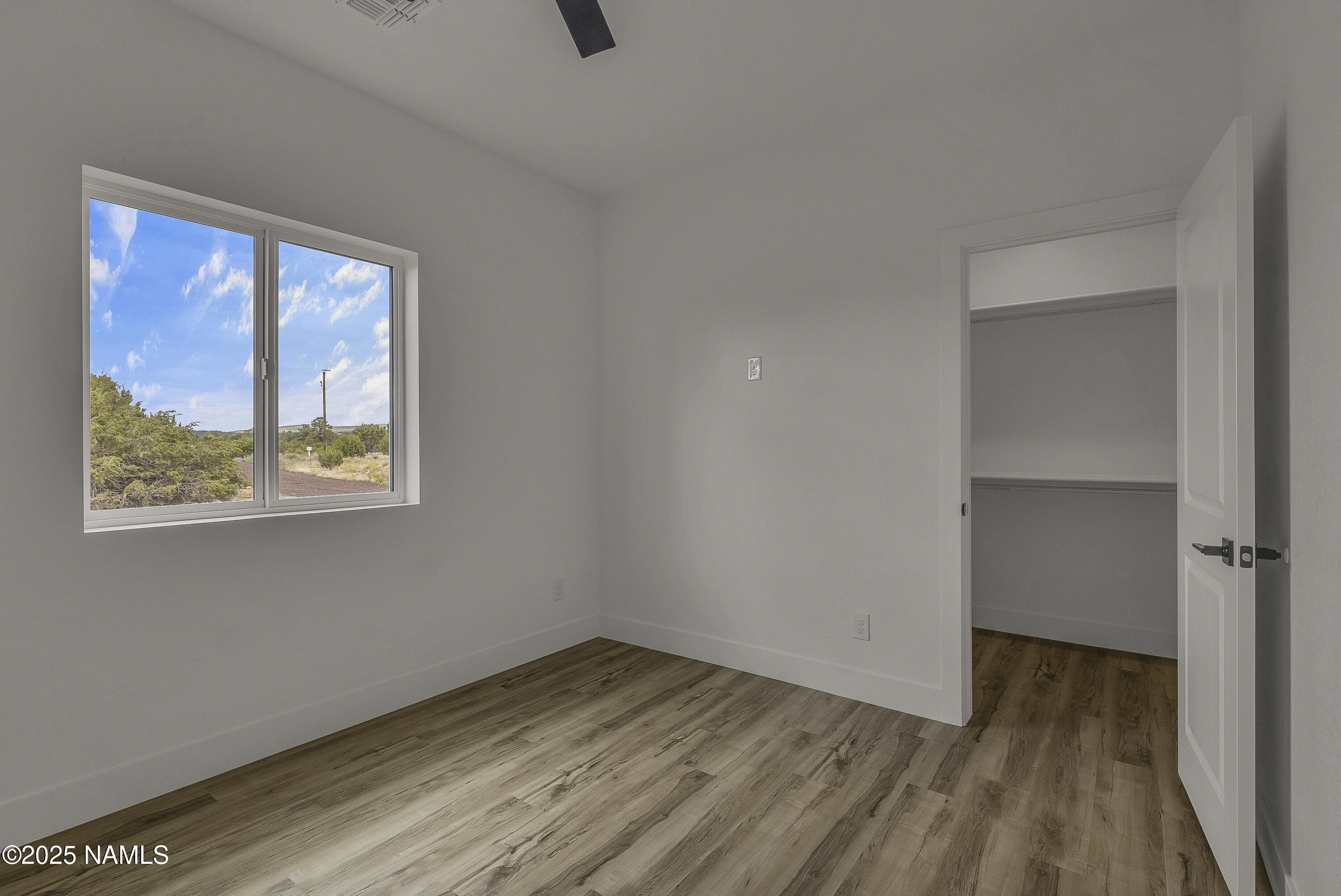 7935 North Red Lake Road Williams, AZ 86046 - Photo 29 of 31 a view of an empty room with a window and wooden floor