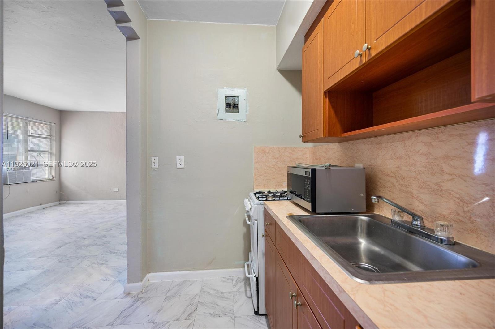 825 Alton Road, Unit 2 Miami Beach, FL 33139 - Photo 5 of 7 a kitchen with a sink and a refrigerator