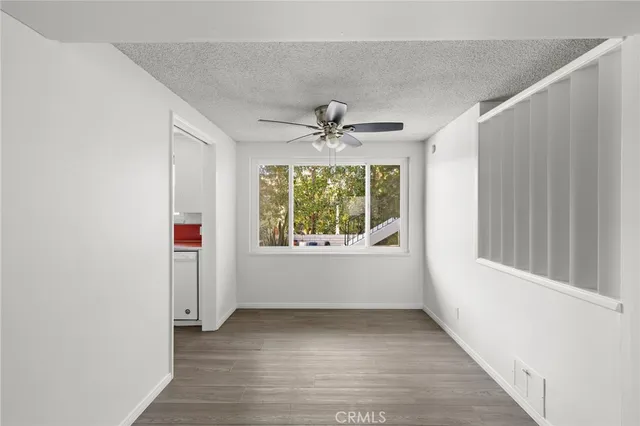an empty room with window and a ceiling fan