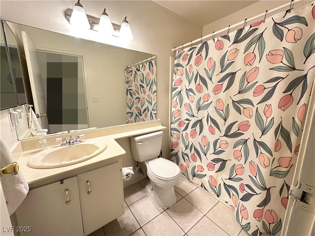 3936 Rive Gauche Street Las Vegas, NV 89115 - Photo 20 of 30 Full bathroom featuring toilet, tile patterned flooring, vanity, and a shower with curtain