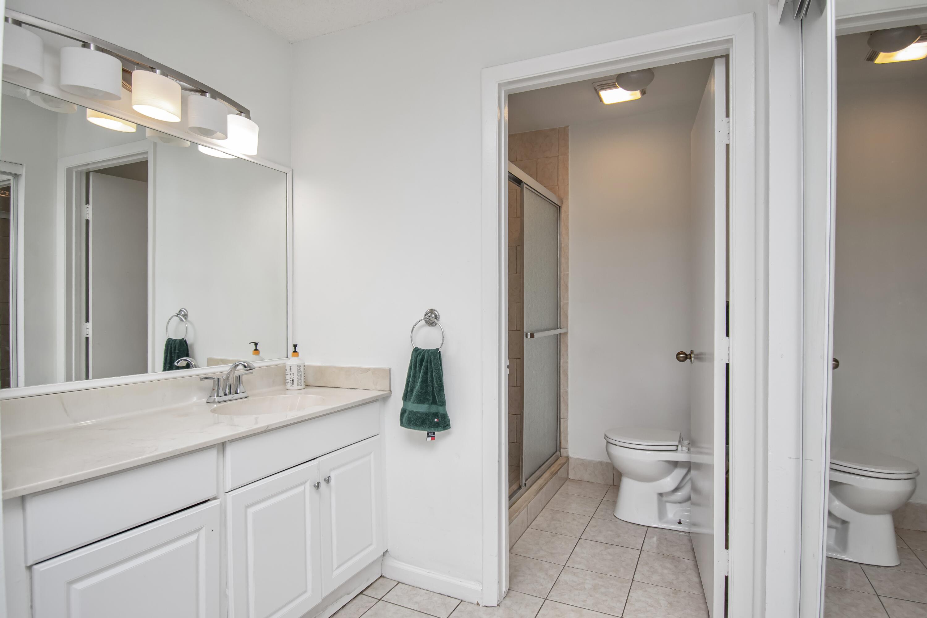 6825 Bridlewood Court Boca Raton, FL 33433 - Photo 19 of 31 a bath room with a toilet a sink and a mirror