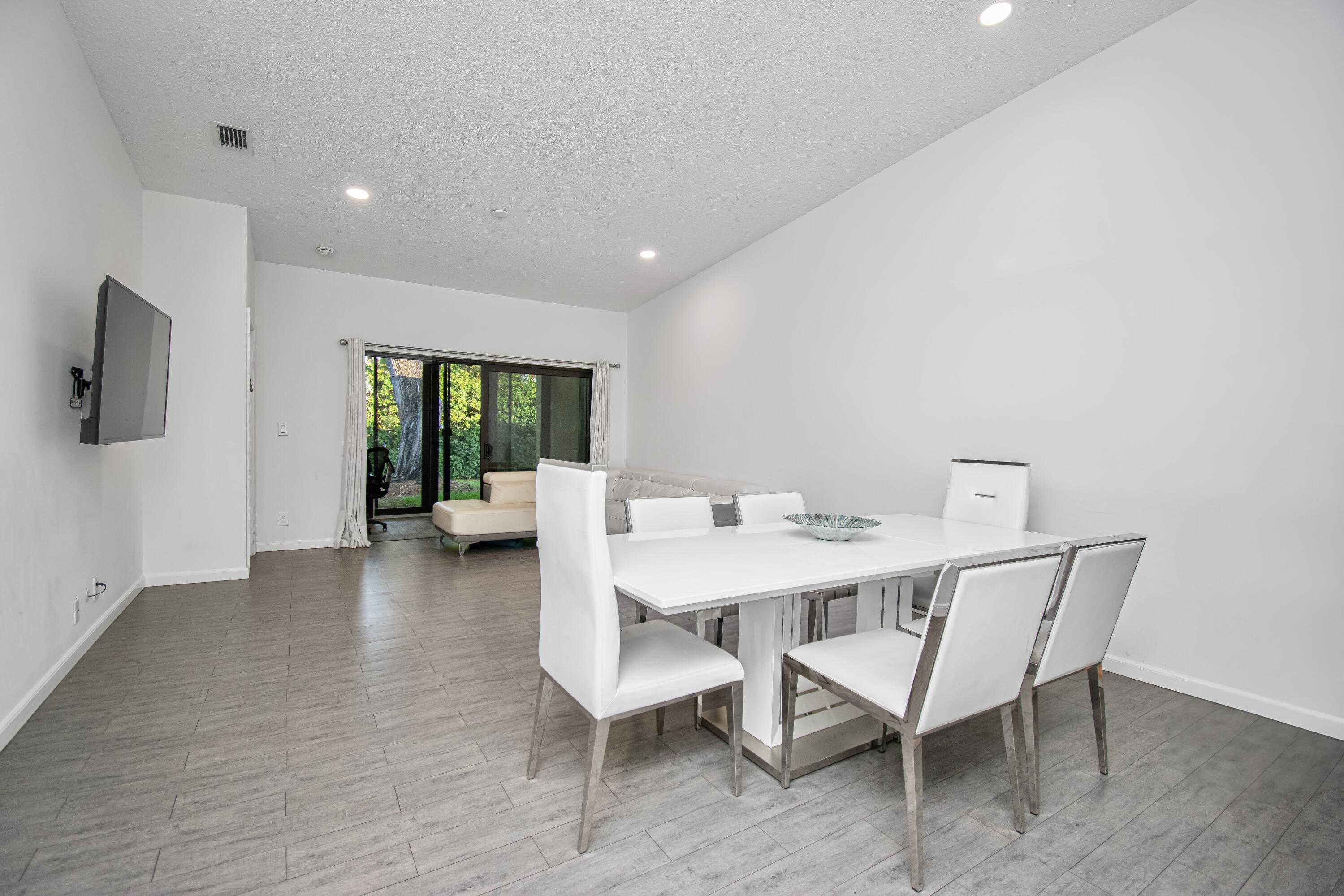 6825 Bridlewood Court Boca Raton, FL 33433 - Photo 5 of 31 a view of a dining room with furniture a fireplace and wooden floor