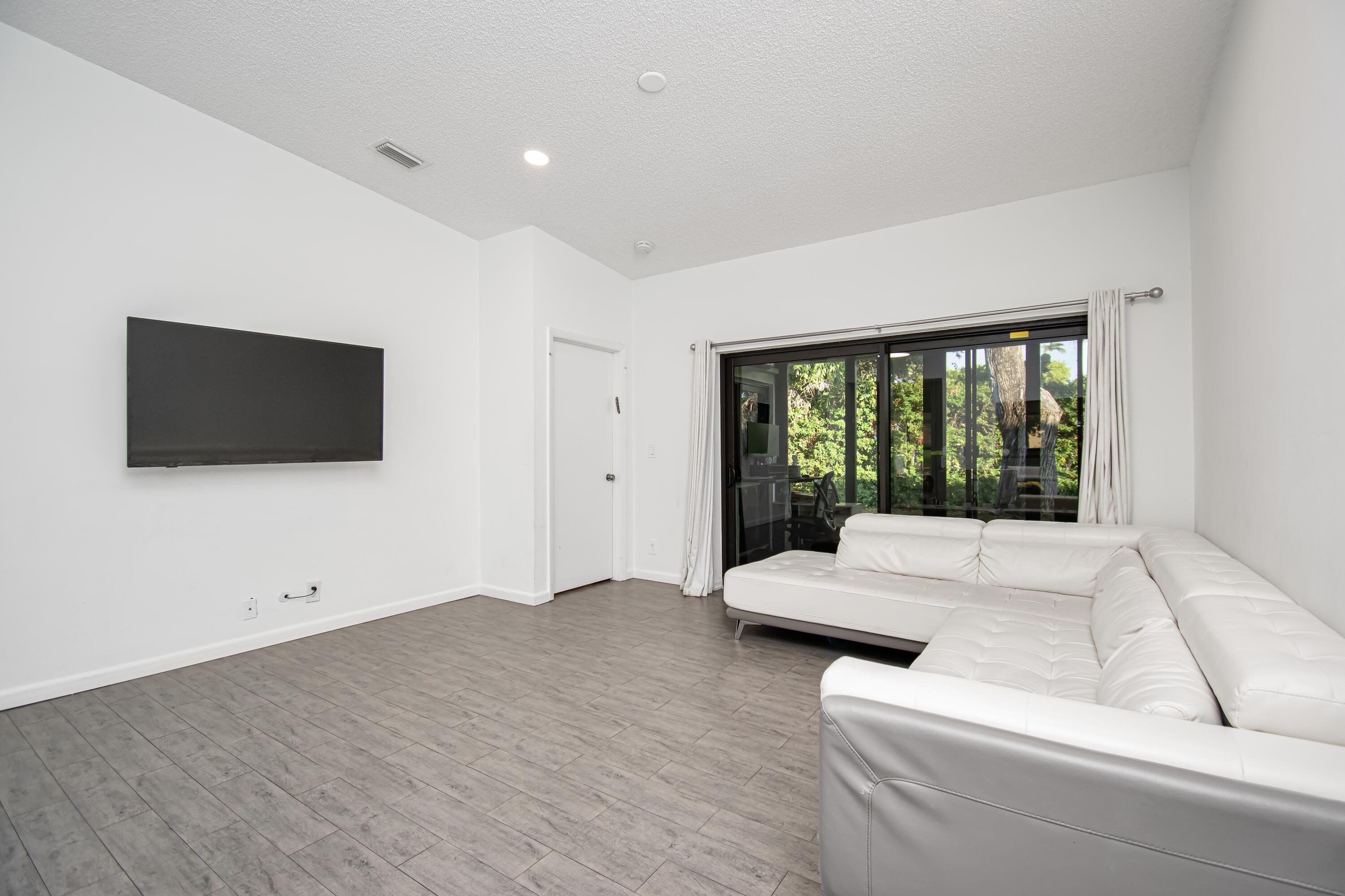 6825 Bridlewood Court Boca Raton, FL 33433 - Photo 7 of 31 a living room with furniture and a flat screen tv