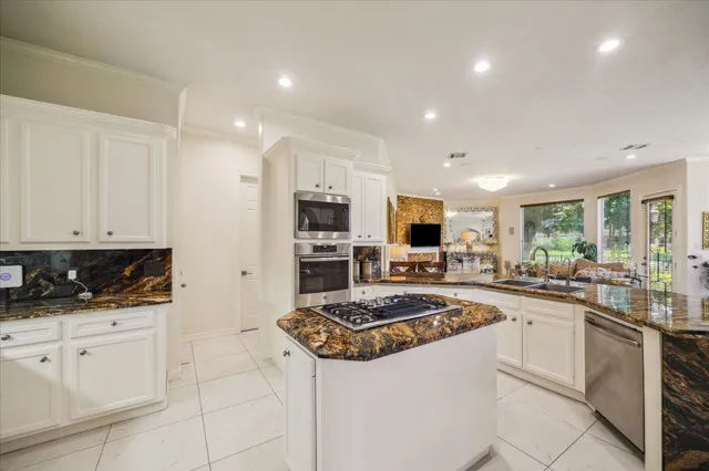 a kitchen with white cabinets and appliances