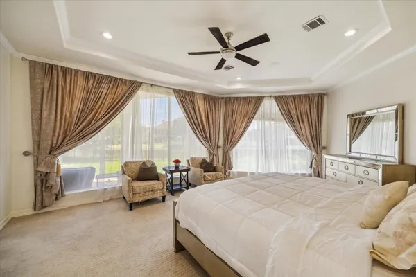 a spacious bedroom with a bed a couch and a large window
