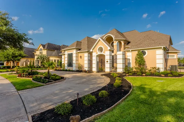 a view of a big house with a big yard and plants