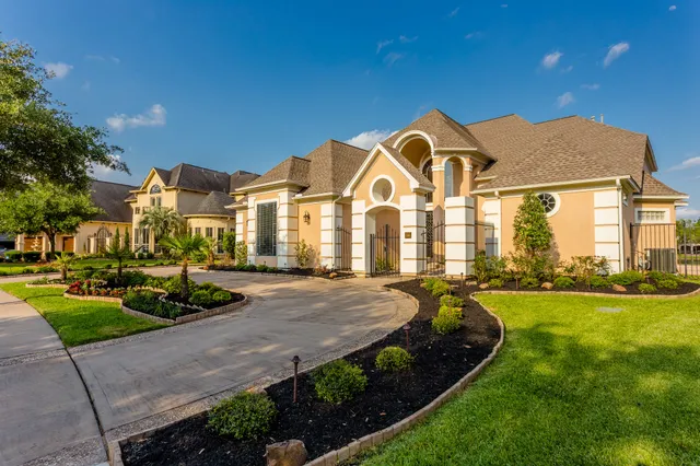 a view of a big house with a big yard and plants