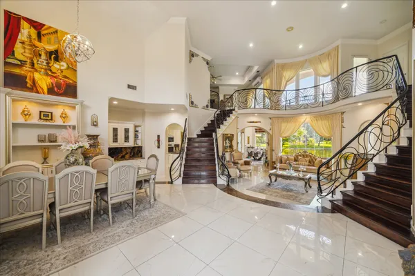 a room with lots of white furniture and a view of living room
