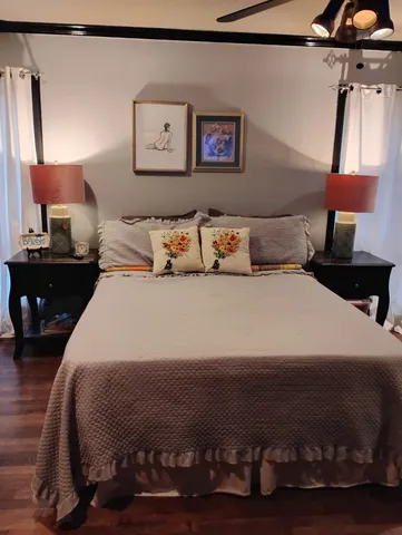 a bedroom with a bed and a lamp on dresser
