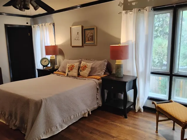 a bedroom with a bed and wooden floor