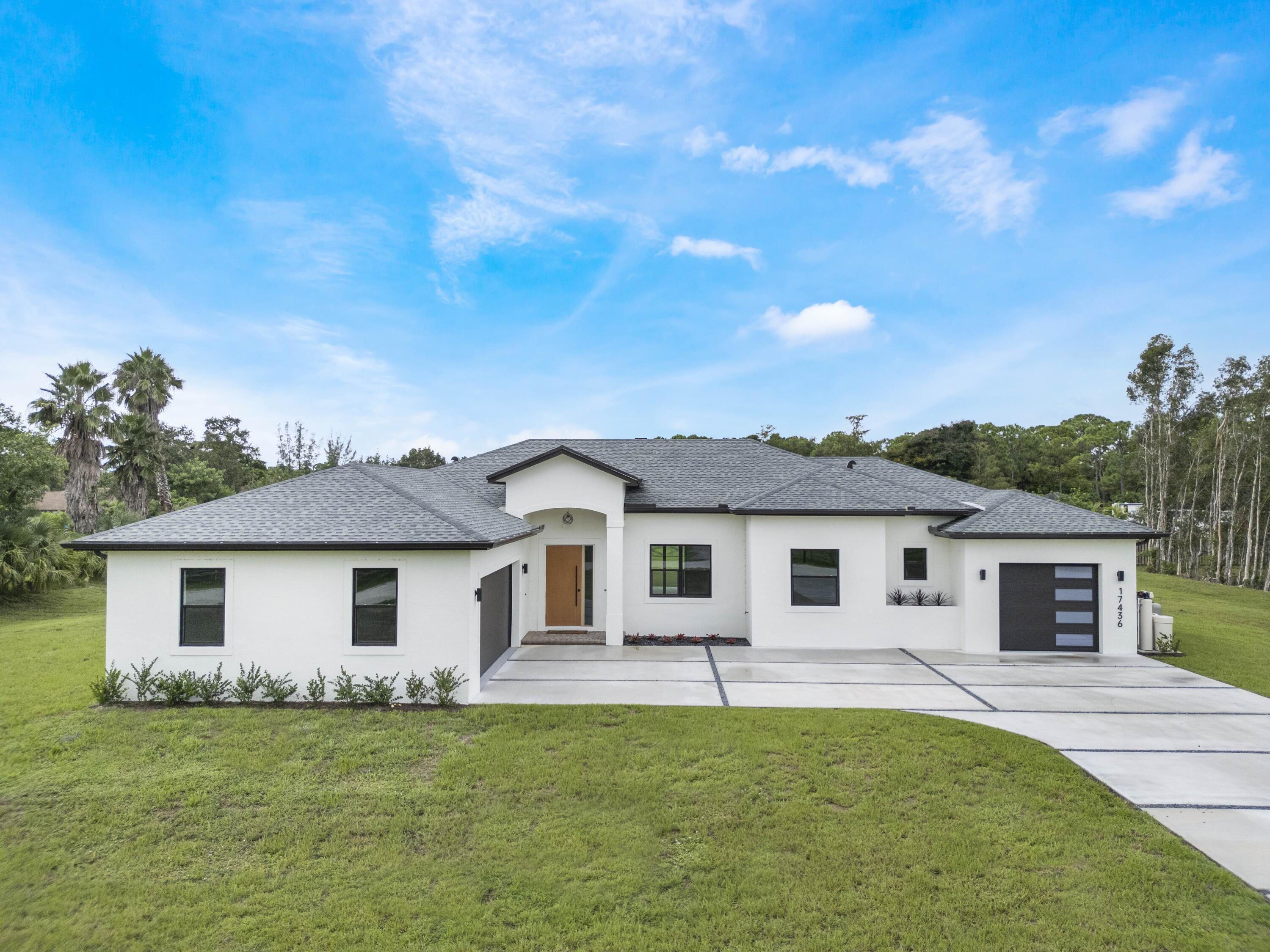17436 71st Lane North Loxahatchee, FL 33470 - Photo 2 of 50 a front view of a house with a garden