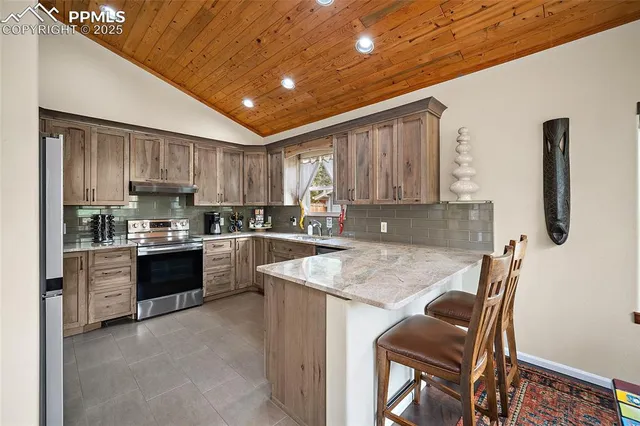 a kitchen with stainless steel appliances granite countertop wooden cabinets a stove top oven a sink and dishwasher