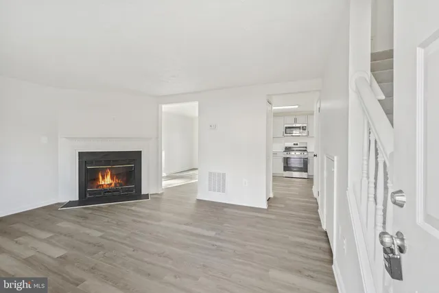 a view of a livingroom with wooden floor and a fireplace