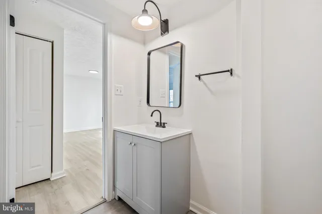a bathroom with a sink a light fixture and a mirror
