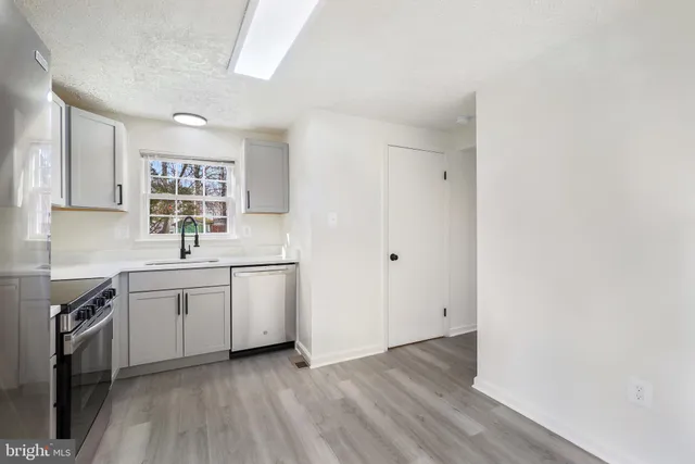 a kitchen with a sink cabinets and wooden floor