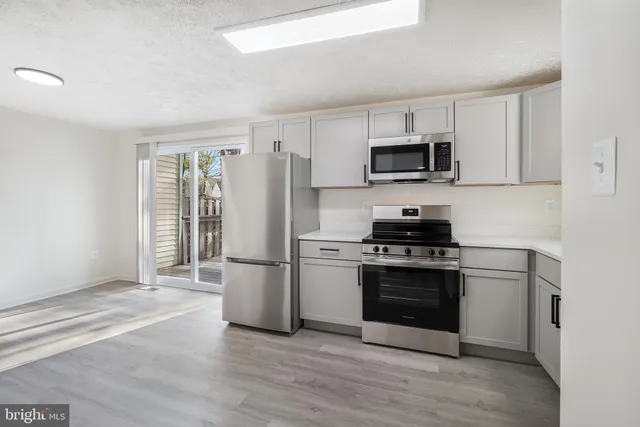 a kitchen with stainless steel appliances granite countertop a stove a refrigerator and a microwave