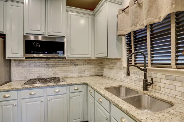 a kitchen with granite countertop a sink and a stove top oven