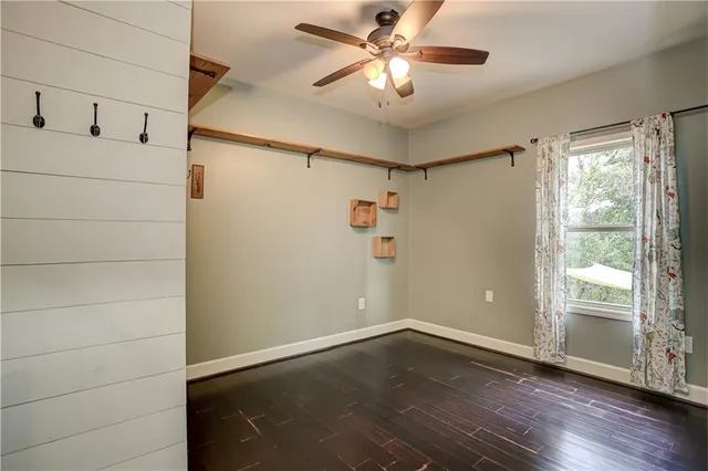 a view of empty room with wooden floor and fan