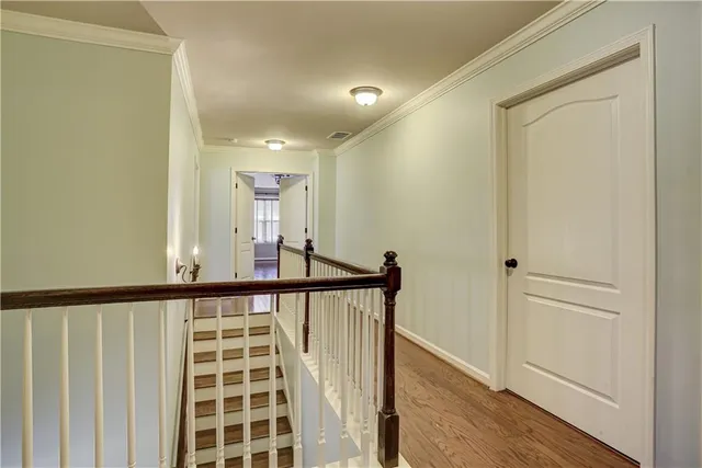 a view of a hallway with wooden floor and staircase
