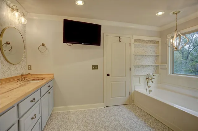 a spacious bathroom with a granite countertop sink a mirror and a bathtub
