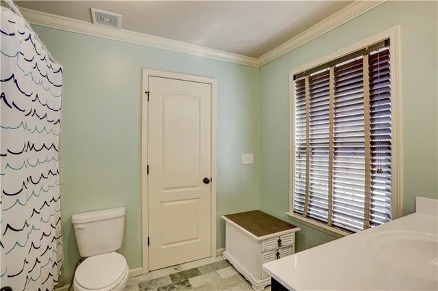 a bathroom with a granite countertop toilet and a sink