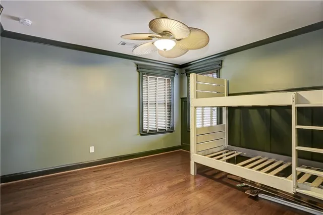 a room with wooden floor and ceiling fan