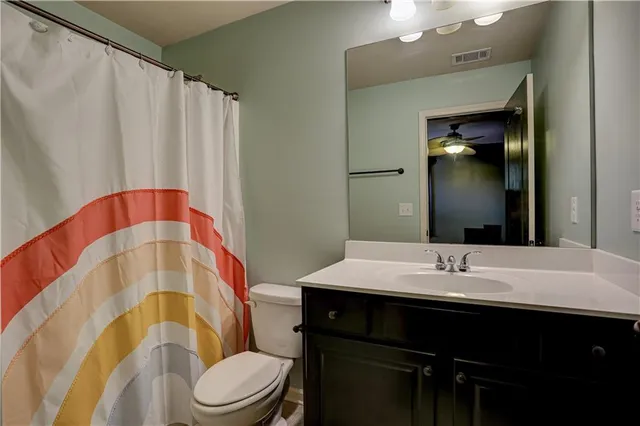 a bathroom with a sink a toilet a mirror and vanity