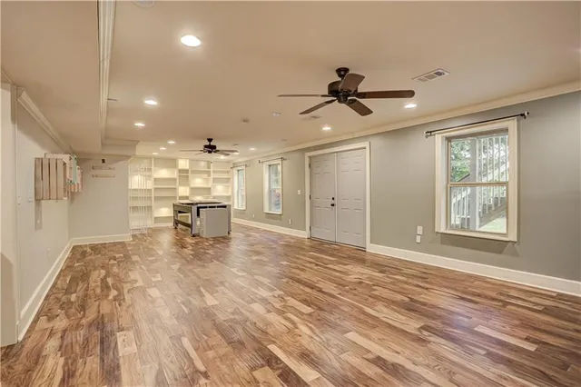 a view of empty room with wooden floor and ceiling fan