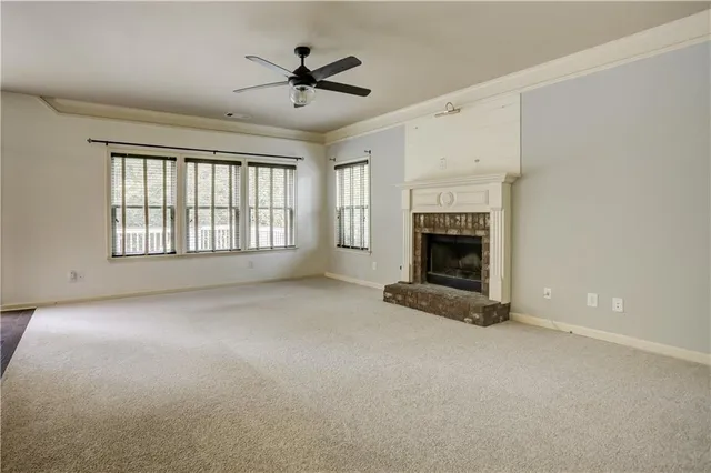 a view of an empty room with a fireplace and a window