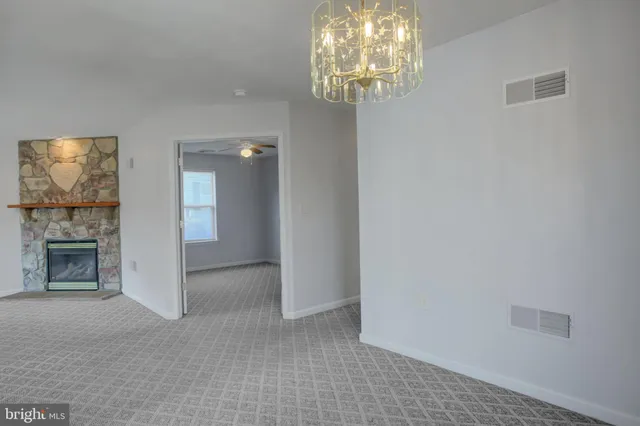 en empty room with windows and chandelier