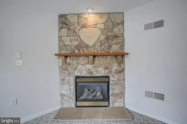 a view of empty room with fireplace and fan