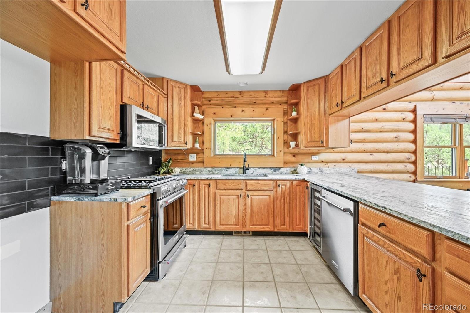 9868 South Overlook Road Sedalia, CO 80135 - Photo 26 of 50 a kitchen with stainless steel appliances granite countertop a sink and dishwasher a stove top oven with wooden floor